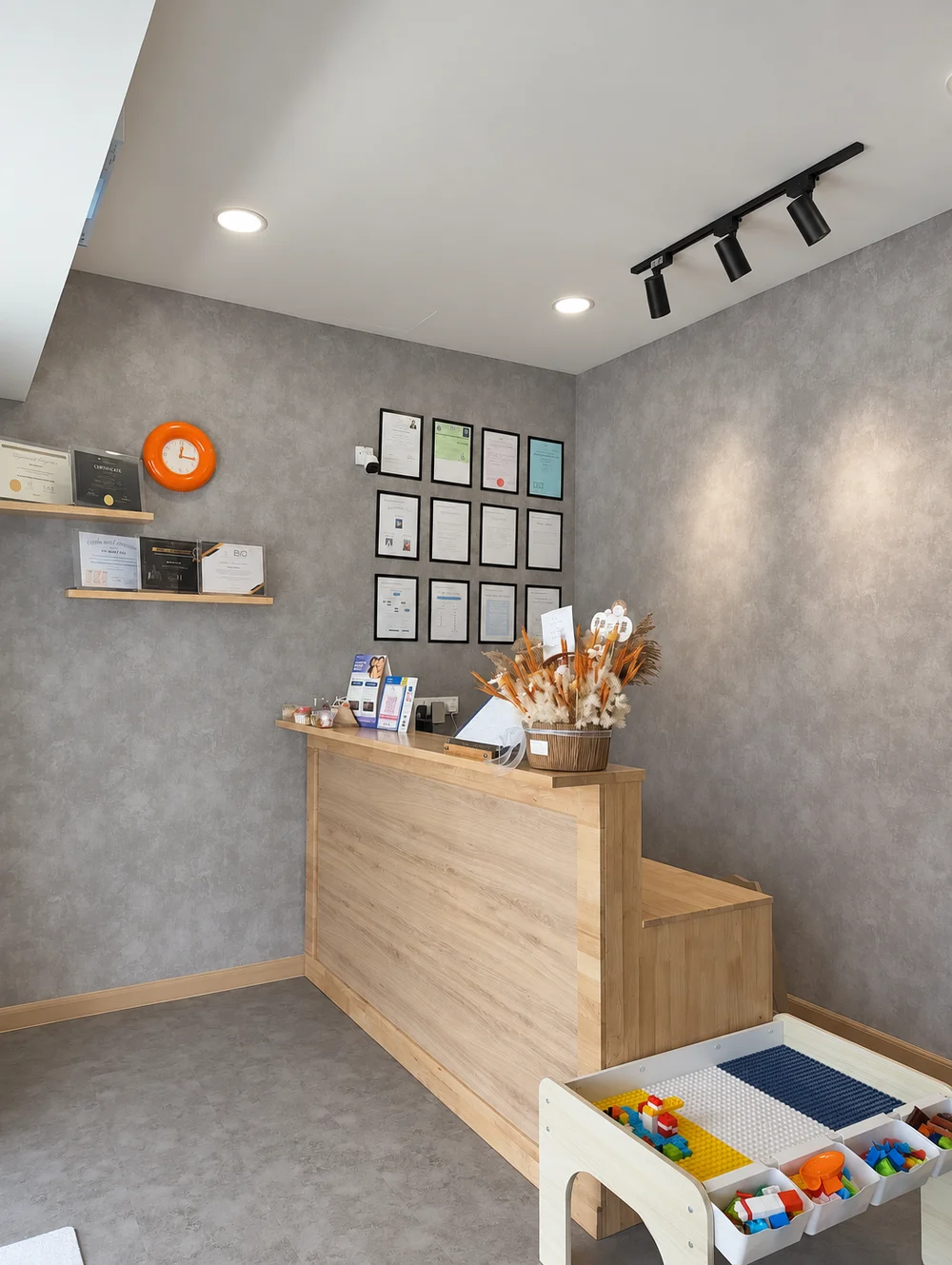Niko dental reception with a wood counter and a children's building-block play table
